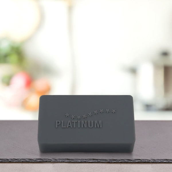 Na pultu stoji črna pravokotna palica z napisom PLATINUM, ki na zamegljenem kuhinjskem ozadju poudarja Štartni paket Puppy - idealno suha in mokra hrana za pse vaše mladiče.